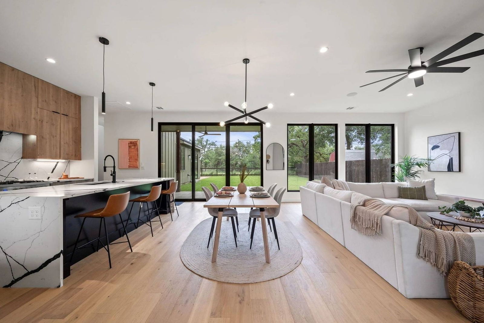 Open great room with wide-plank oak floors and sliding glass doors