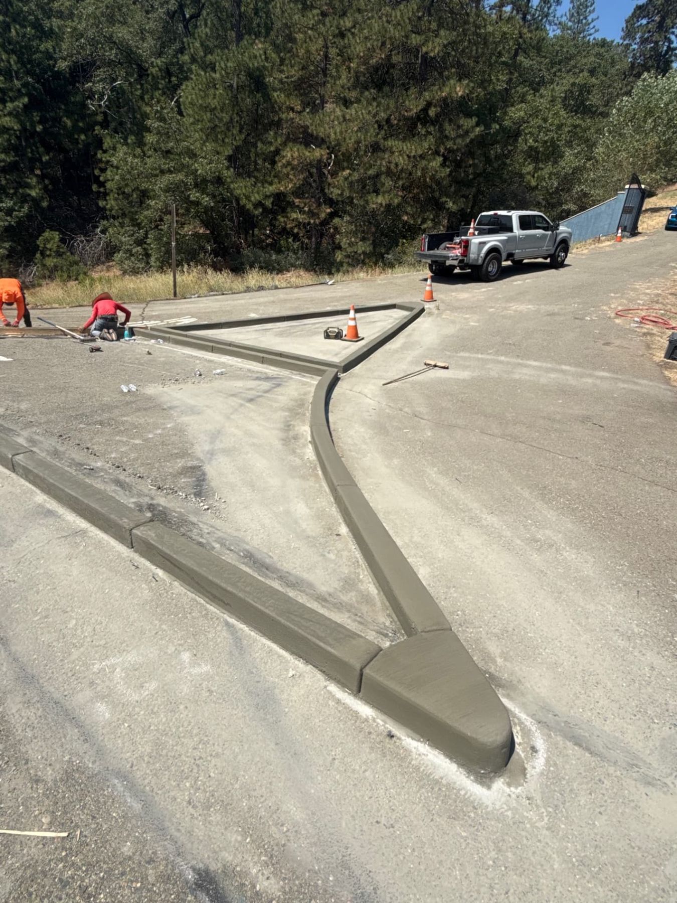 Freshly finished concrete curb and gutter island with hand troweled radius returns on a highway approach