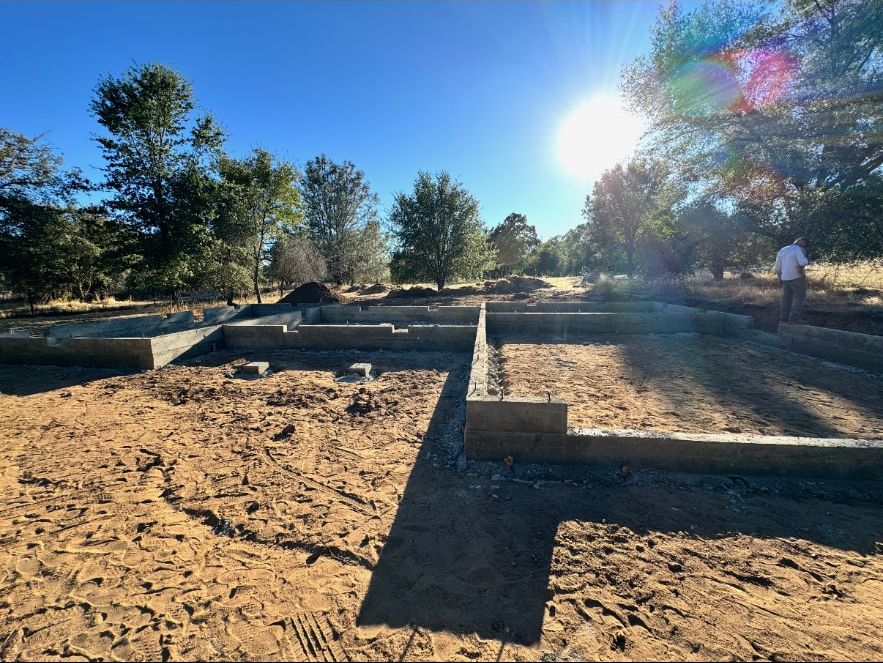 Completed stem wall foundation and interior footings photographed at sunrise before framing starts