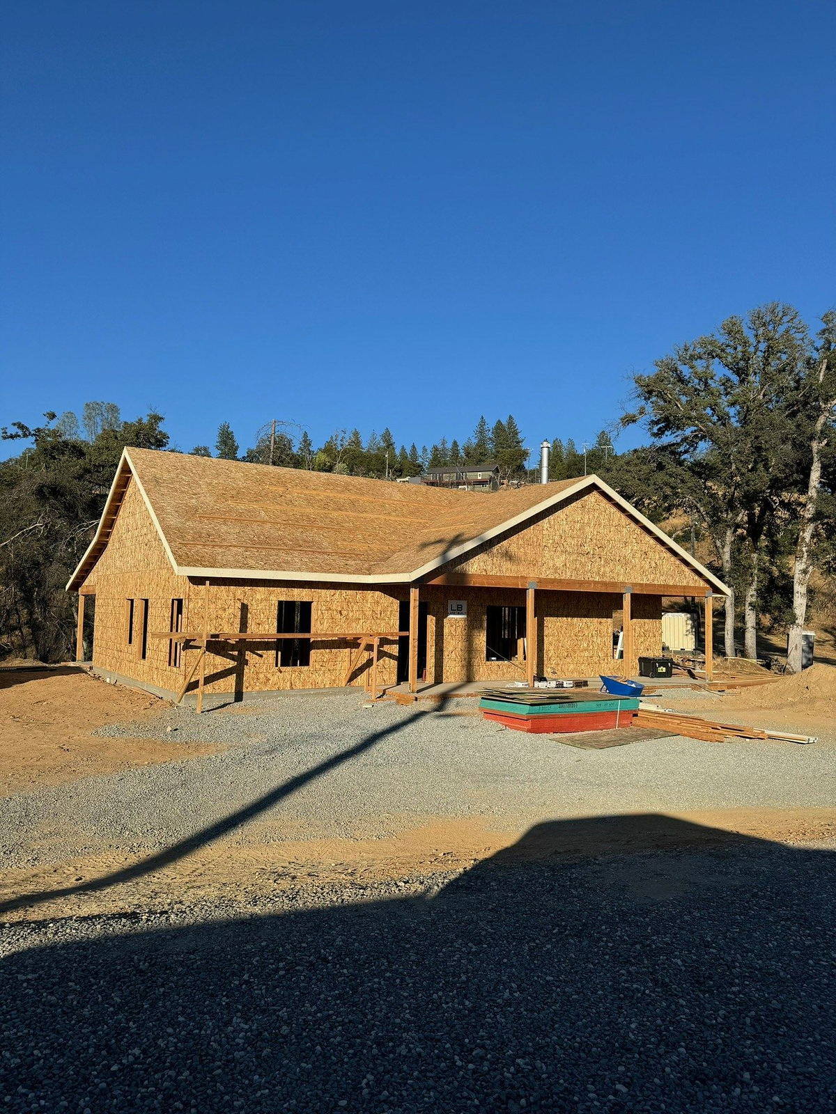 Custom home at the framing stage with window openings cut and roof sheathing on