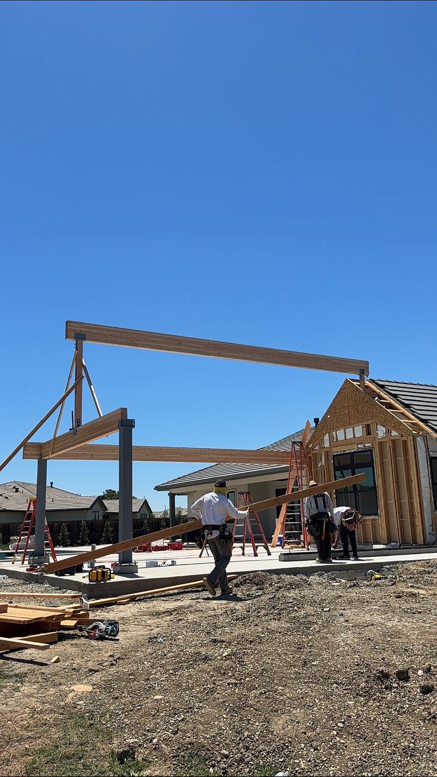 Lane Built crew setting a glulam ridge beam on steel posts over a new covered patio slab