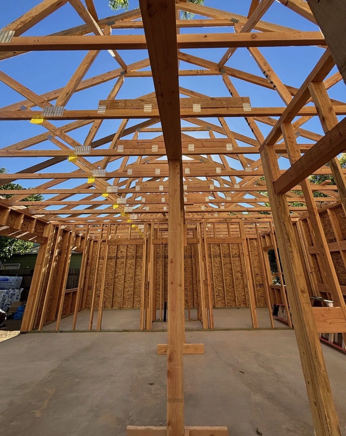 Interior view of roof trusses and framed walls from the slab of a Lane Built garage build