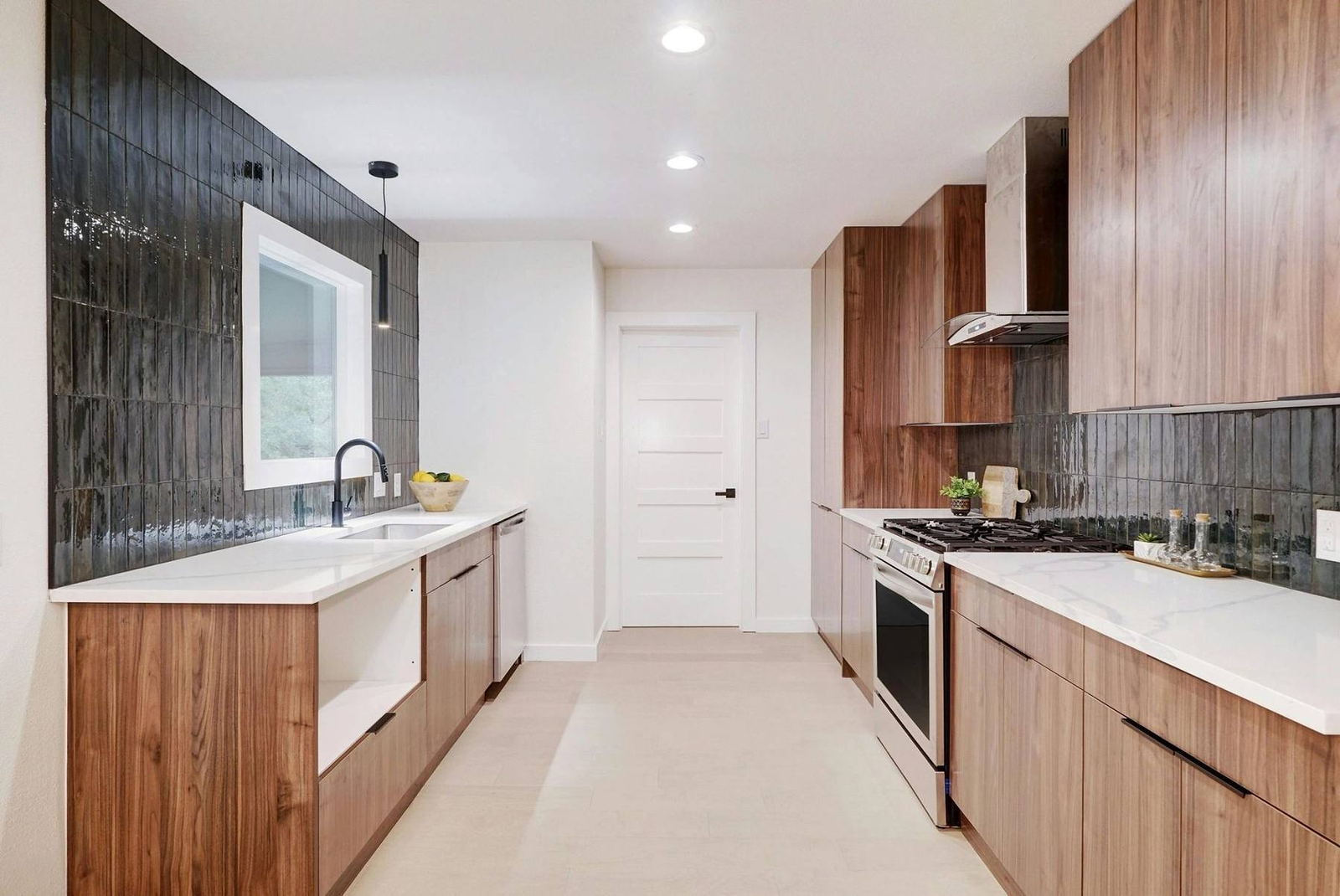 Galley kitchen with walnut cabinetry, farmhouse sink and glazed tile backsplash