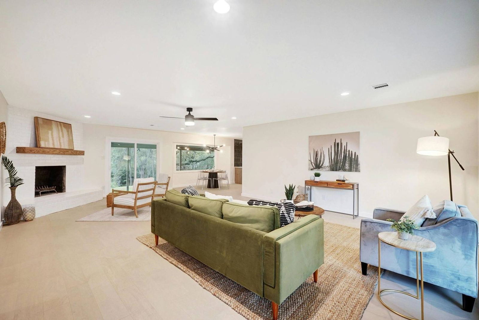 Bright living room with green sofa, oak floors and doors opening to the backyard