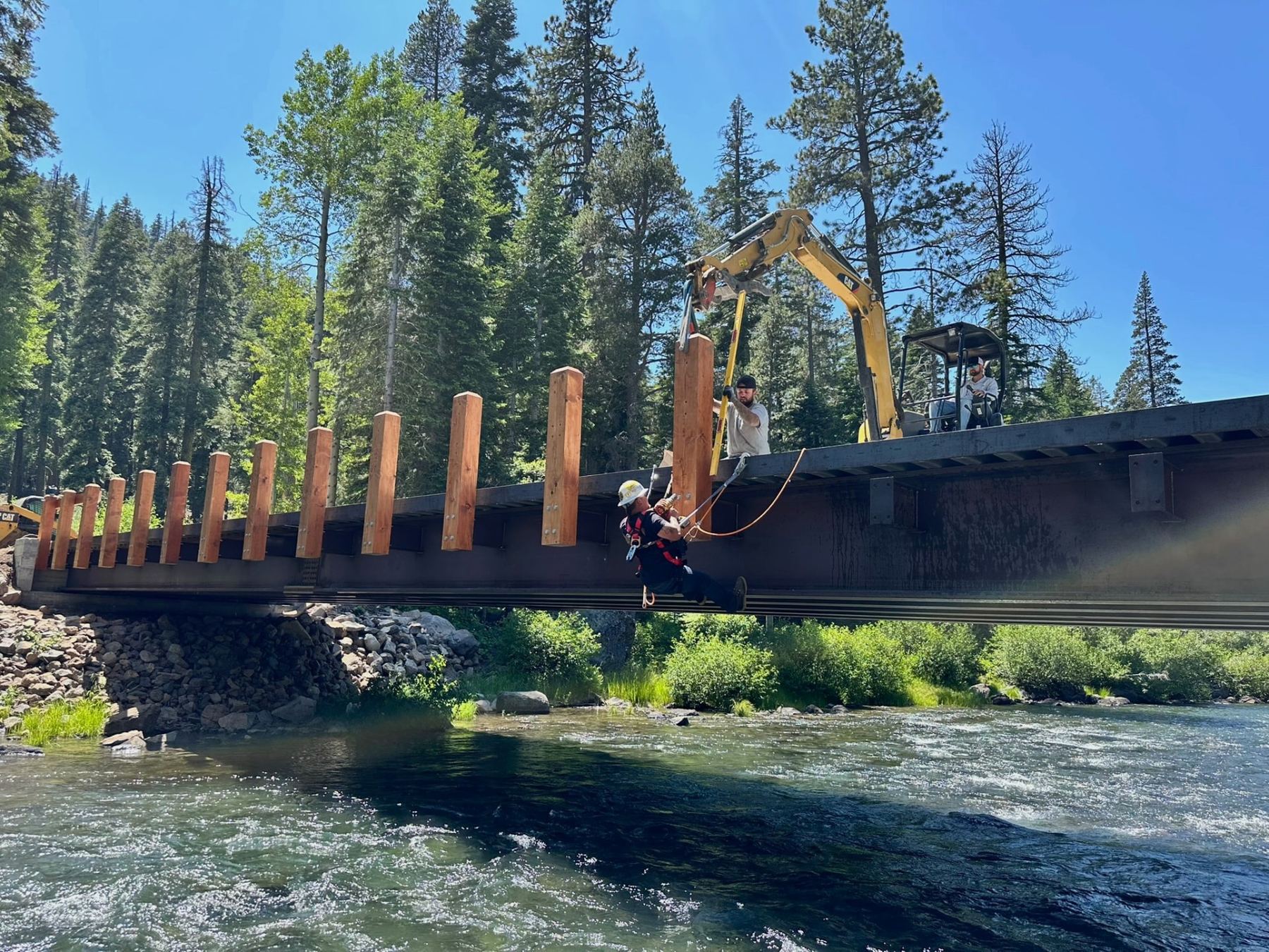 Lane Built Inc. crew of three setting timber rail posts on a bridge deck