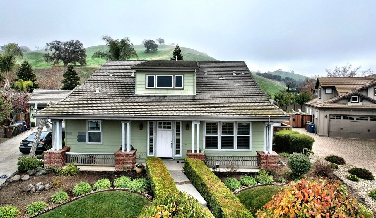 Craftsman home with sage siding and white trim after an exterior repaint in the foothills