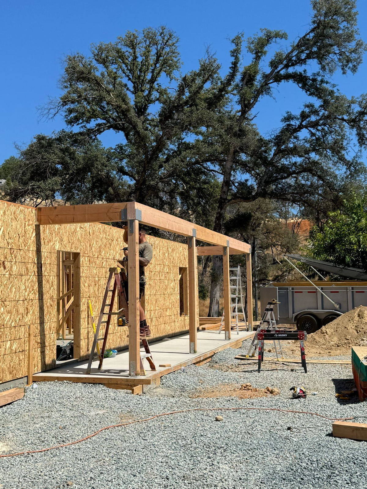 Exterior walls standing on a new slab during the framing stage of a custom build