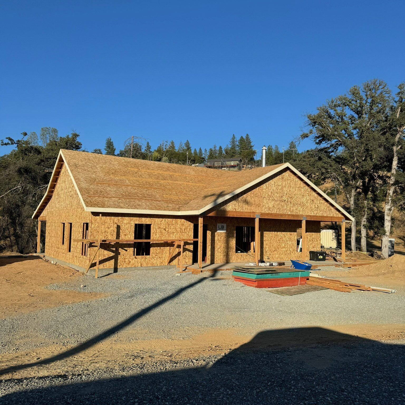 Sheathed custom home with the front porch framed and roof decking in place