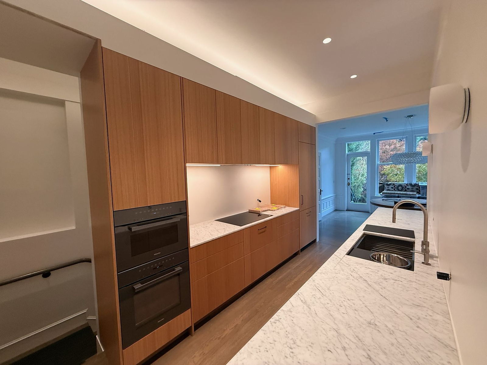Walnut slab cabinetry and quartz counters in a Lane Built Inc. custom home kitchen
