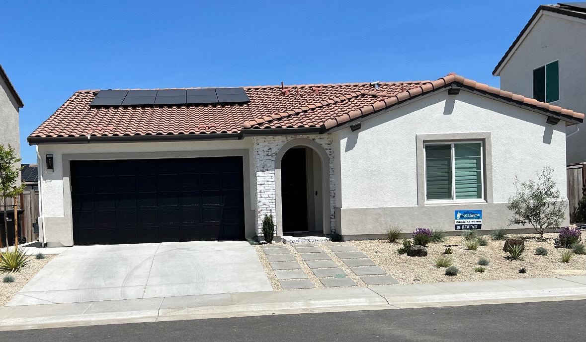 White stucco single-story home with a clay tile roof and drought tolerant landscaping